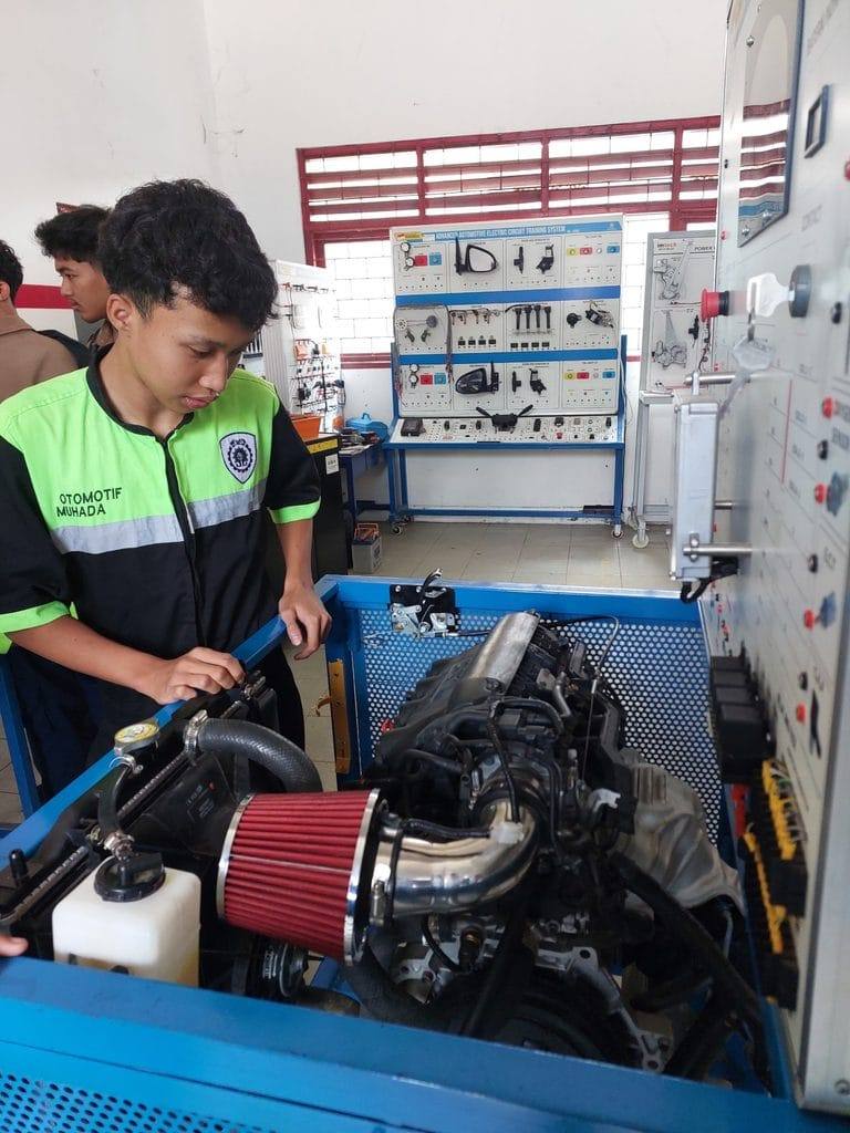Siswa TKR mengerjakan asesmen pada engine trainer
