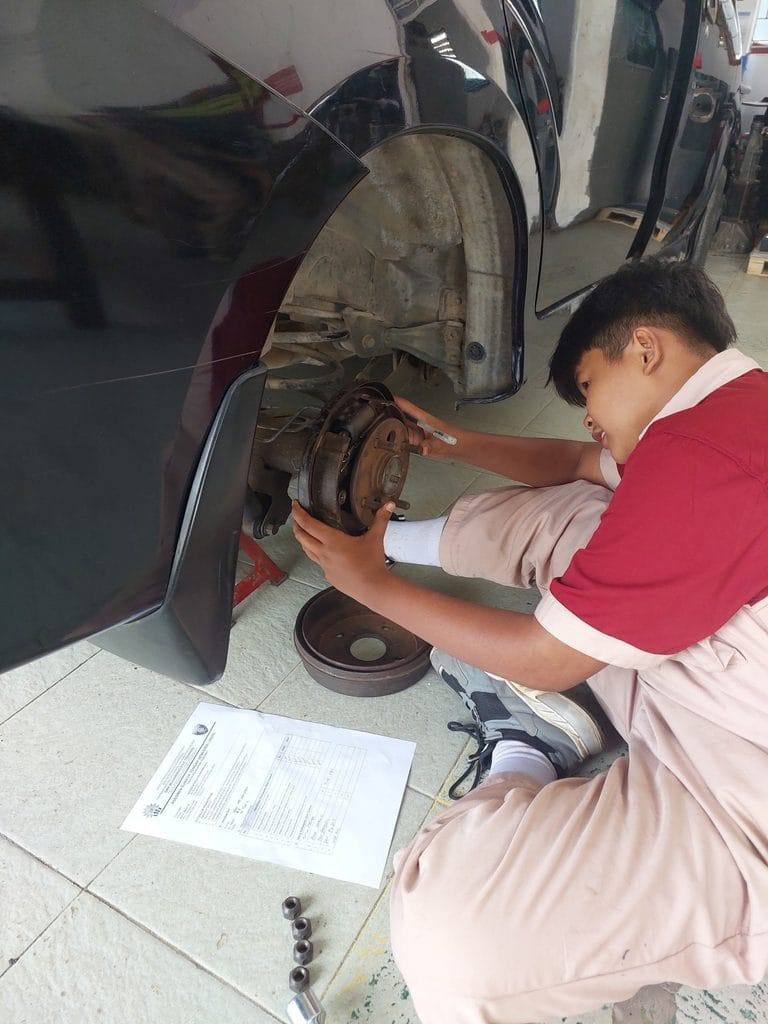 Siswa TKR mengerjakan asesmen sistem rem dan roda